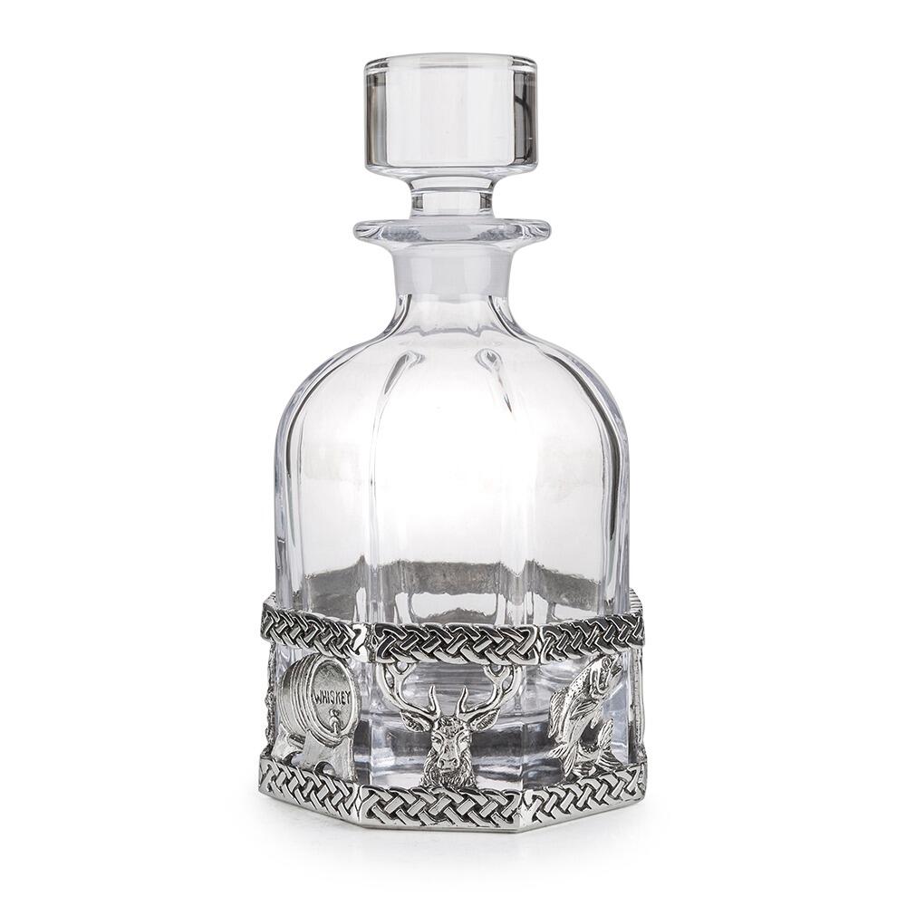 A glass decanter with a Pewter base and scottish designs