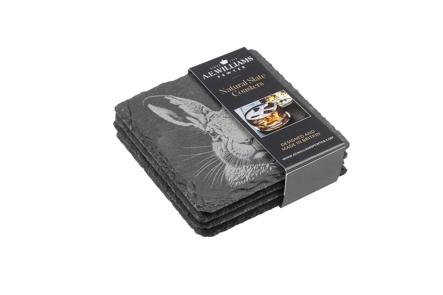 The top coaster features an engraved hare design. A product label wraps around the stack, displaying the brand name, product type 'Natural Slate Coasters', and an image of a whiskey glass on a coaster. The label states 'Designed and Made in Britain' and includes the company website.