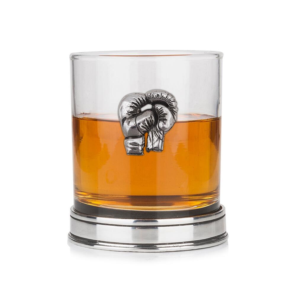 Whisky tumbler with pewter boxing gloves emblem and polished base, partially filled with amber liquid