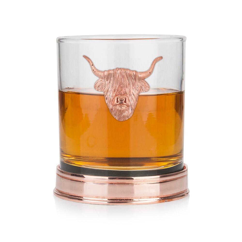 Whisky tumbler with Copper Highland Cow emblem and polished Copper base, partially filled with amber liquid