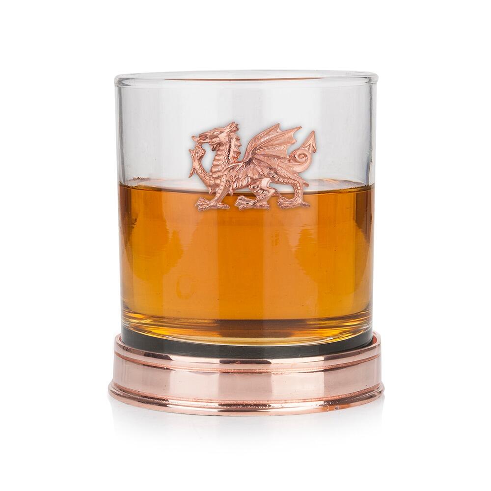 Whisky tumbler with a Copper Welsh Dragon emblem and polished Copper base, partially filled with amber liquid