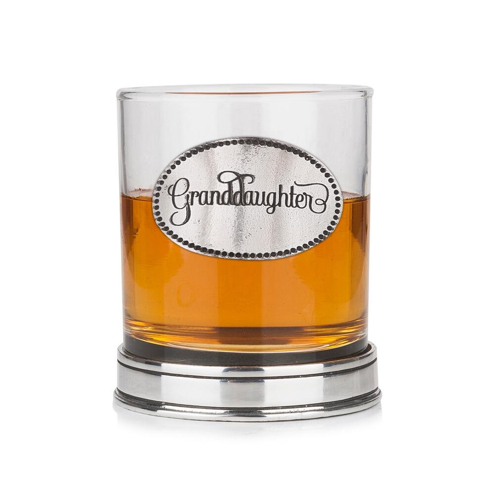 Whisky tumbler with pewter 'Granddaughter' badge and polished base, partially filled with amber liquid