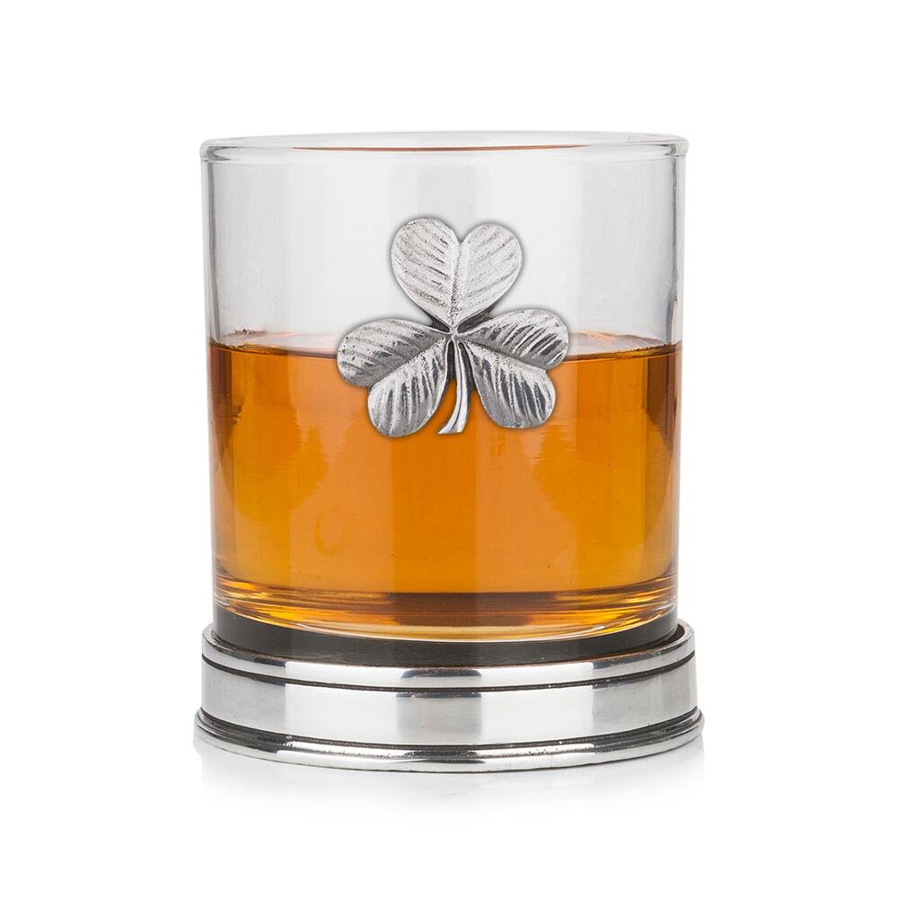 Whisky tumbler with pewter shamrock motif and polished base, partially filled with amber liquid