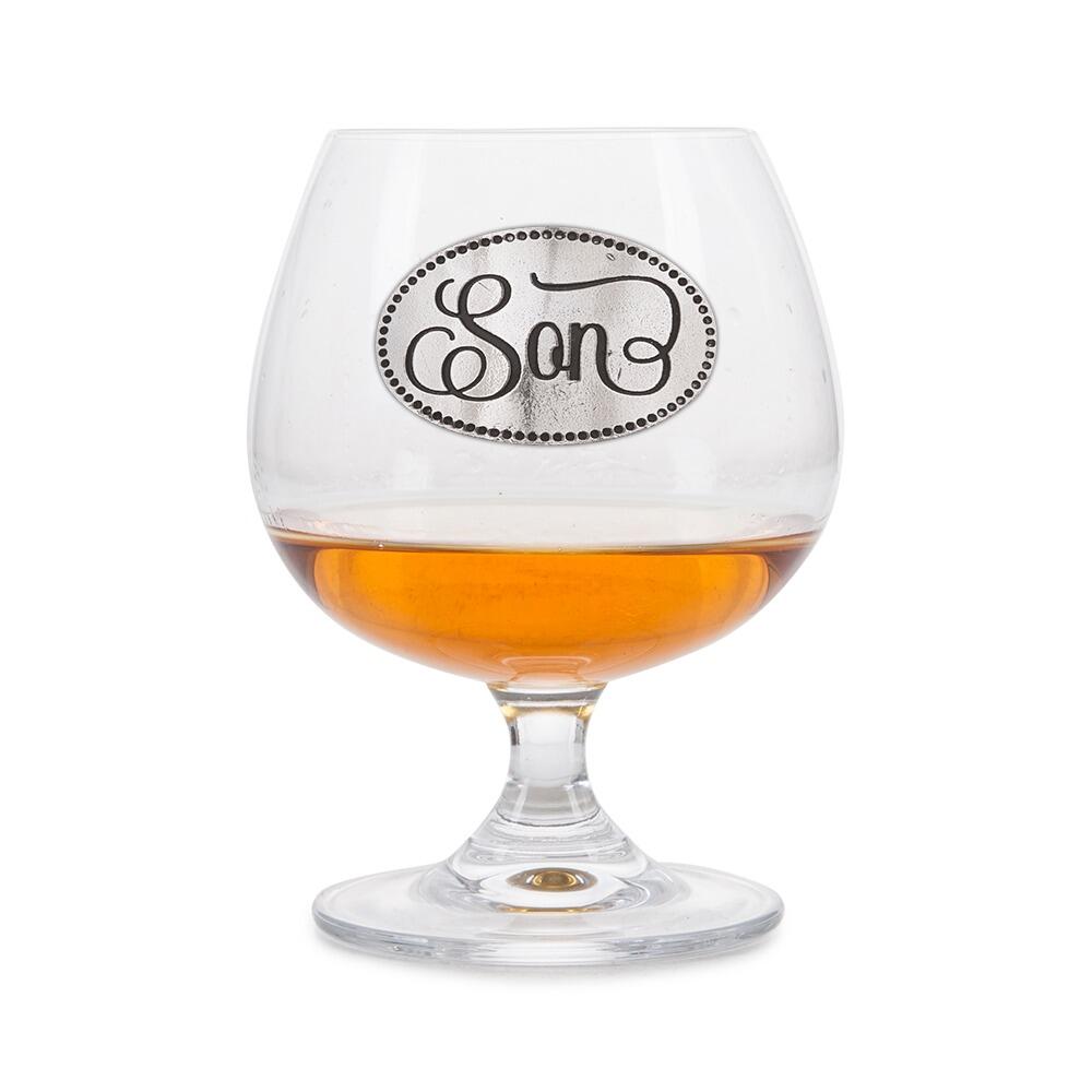 Crystal brandy glass with pewter 'Son' badge, partially filled with amber liquid
