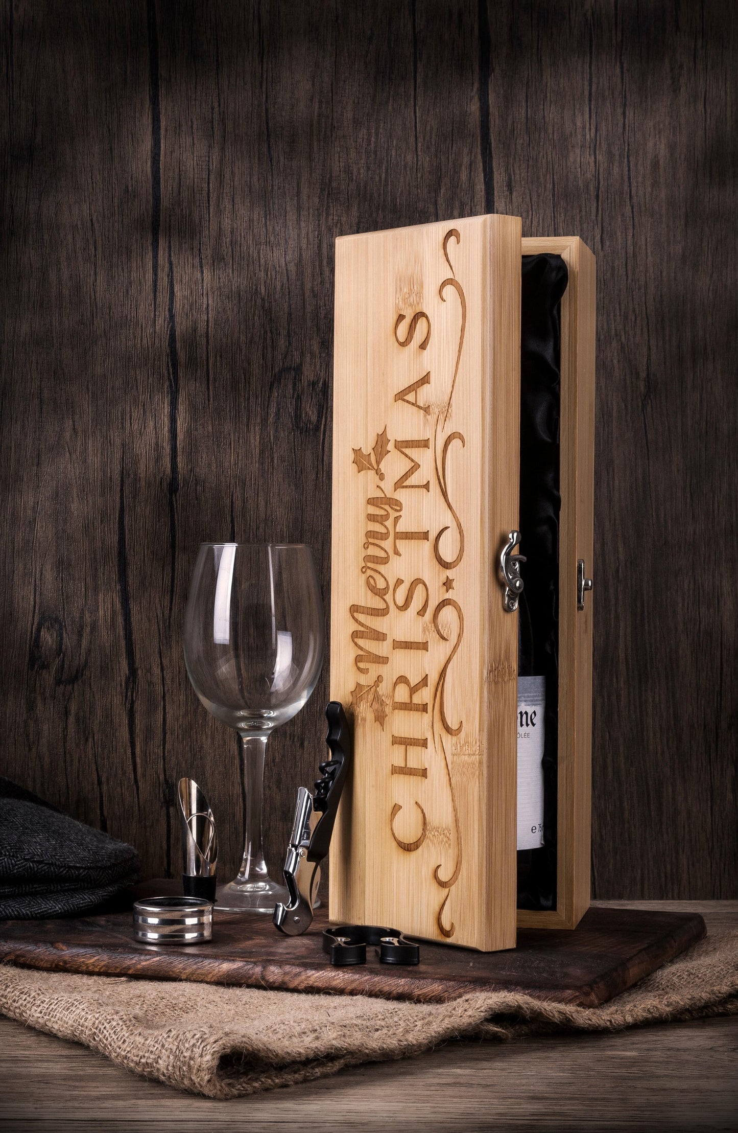 Festive Christmas wooden presentation box with holly leaf design and decorative engraving, featuring luxury wine accessories