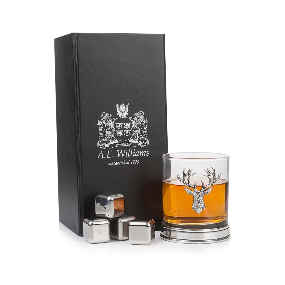 a whisky tumbler with a stag head and pewter base, next to a box with 4 resuable whisky stones
