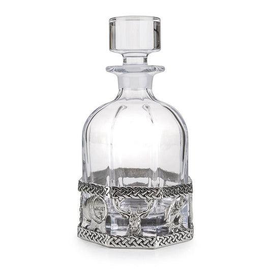 A glass decanter with a Pewter base and scottish designs