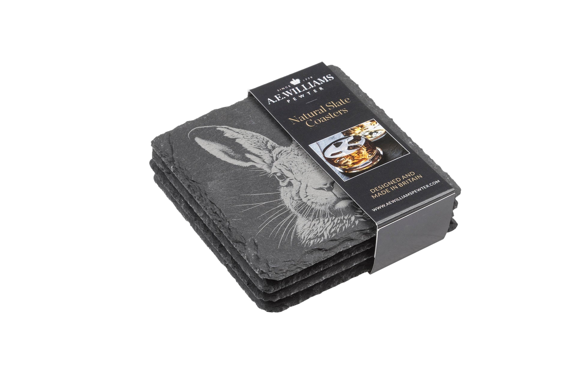 The top coaster features an engraved hare design. A product label wraps around the stack, displaying the brand name, product type 'Natural Slate Coasters', and an image of a whiskey glass on a coaster. The label states 'Designed and Made in Britain' and includes the company website.