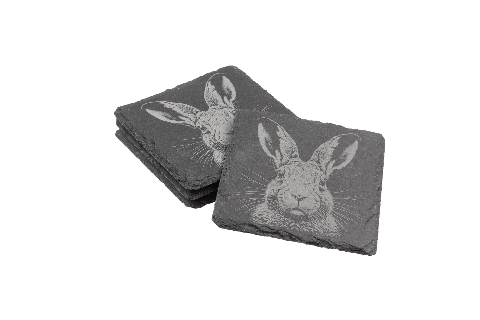 Two stacks of square slate coasters, each engraved with a detailed hare design.