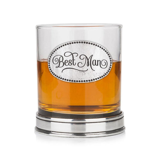 Whisky tumbler with pewter 'Best Man' badge and polished base, partially filled with amber liquid