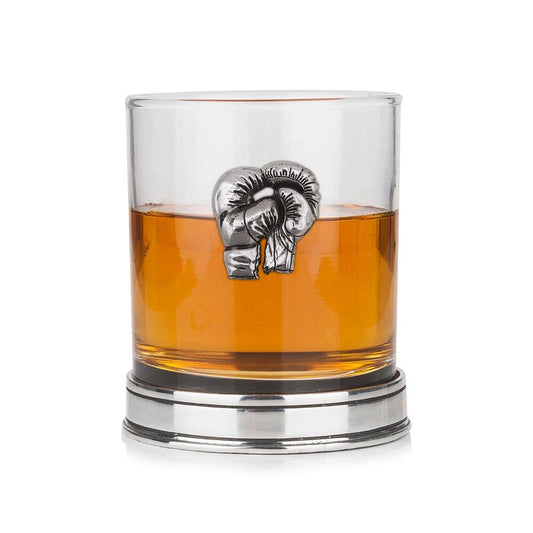 Whisky tumbler with pewter boxing gloves emblem and polished base, partially filled with amber liquid