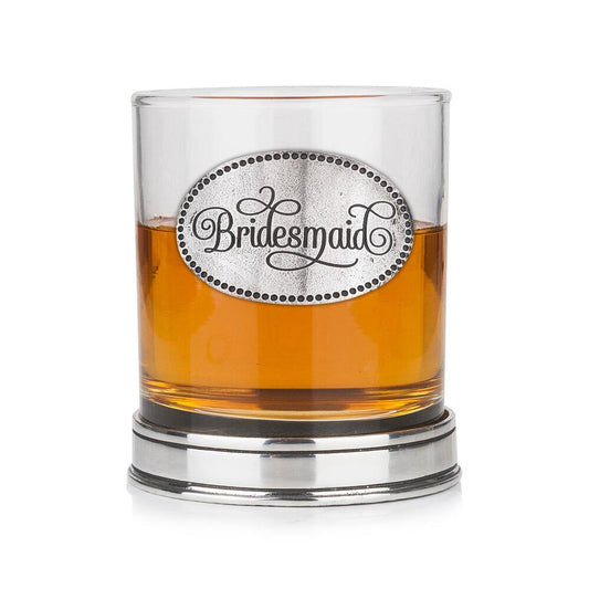 Whisky tumbler with pewter 'Bridesmaid' badge and polished base, partially filled with amber liquid