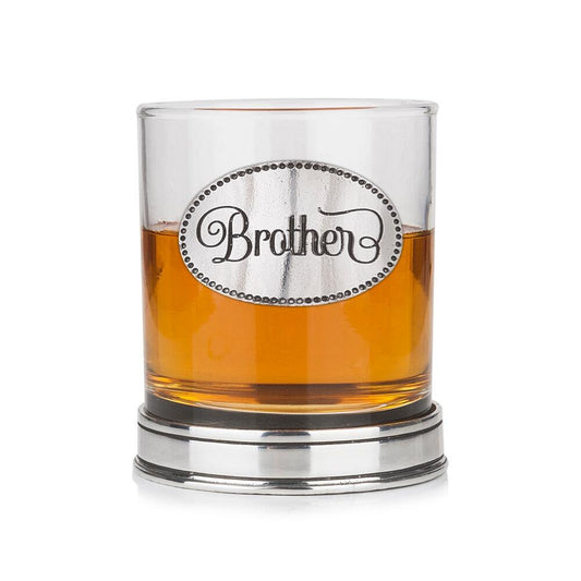 Whisky tumbler with pewter 'Brother' badge and polished base, partially filled with amber liquid