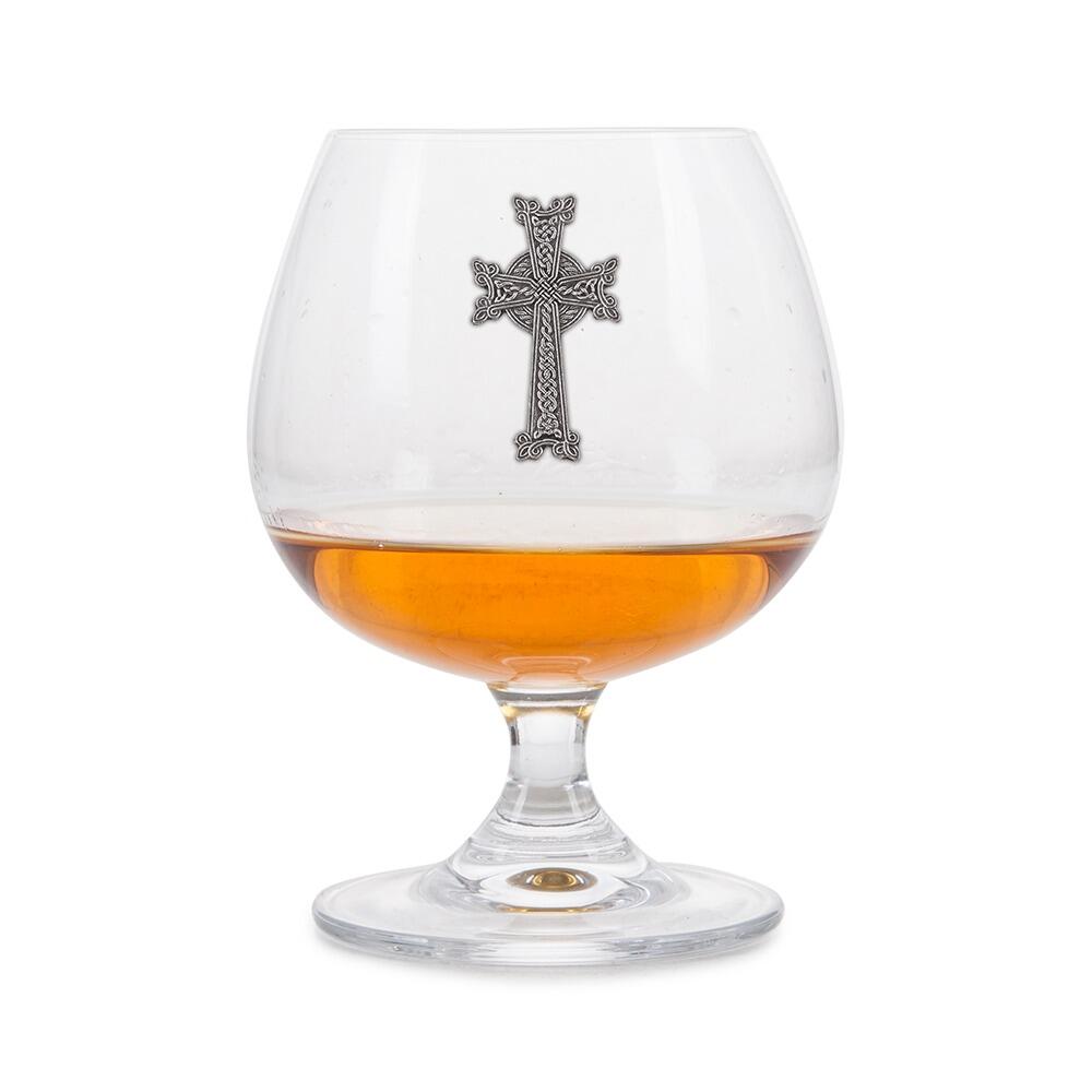 Crystal brandy glass with pewter Celtic Cross emblem, partially filled with amber liquid