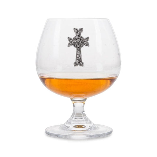 Crystal brandy glass with pewter Celtic Cross emblem, partially filled with amber liquid