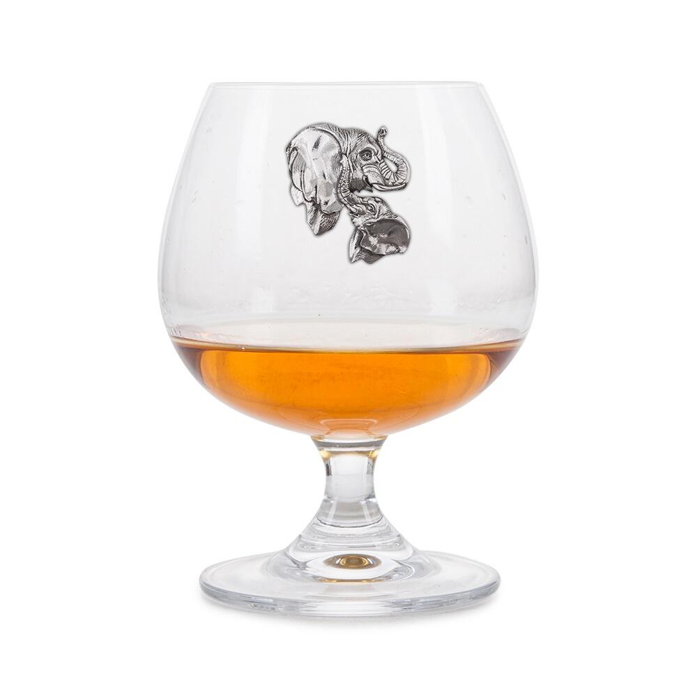 Crystal brandy glass with pewter elephant emblem, partially filled with amber liquid