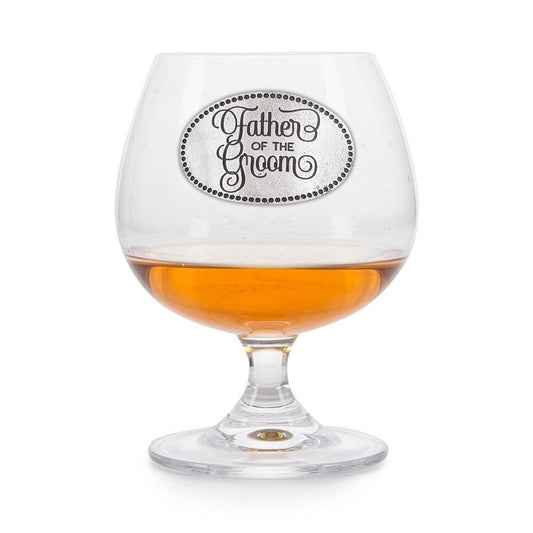 Crystal brandy glass with pewter "Father of the Groom" badge, partially filled with amber liquid