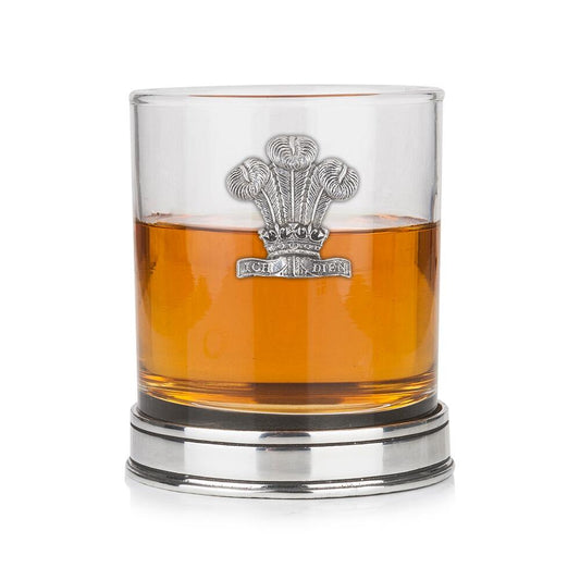 Whisky tumbler with pewter Welsh Feathers emblem and polished base, partially filled with amber liquid