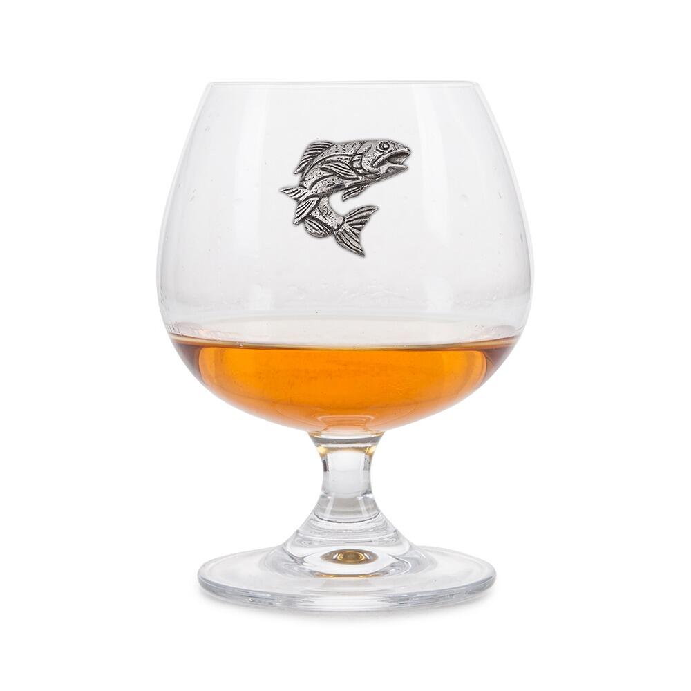 Crystal brandy glass with A E Williams pewter salmon emblem, partially filled with amber liquid