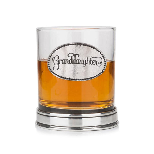 Whisky tumbler with pewter 'Granddaughter' badge and polished base, partially filled with amber liquid