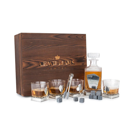 A.E. Williams Pewter whiskey gift set featuring a wooden box, glass decanter with playing card design, four whiskey glasses with card suit emblems, whiskey stones, and tongs
