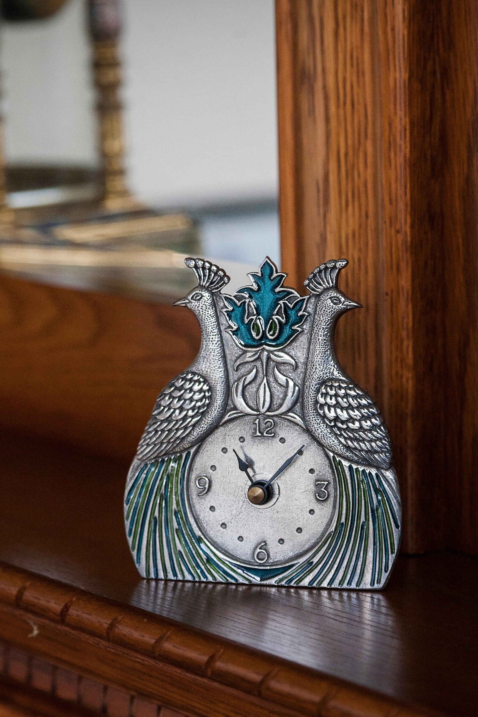 Pewter desk clock featuring two peacocks with blue and green enamelled feathers sitting on a desk