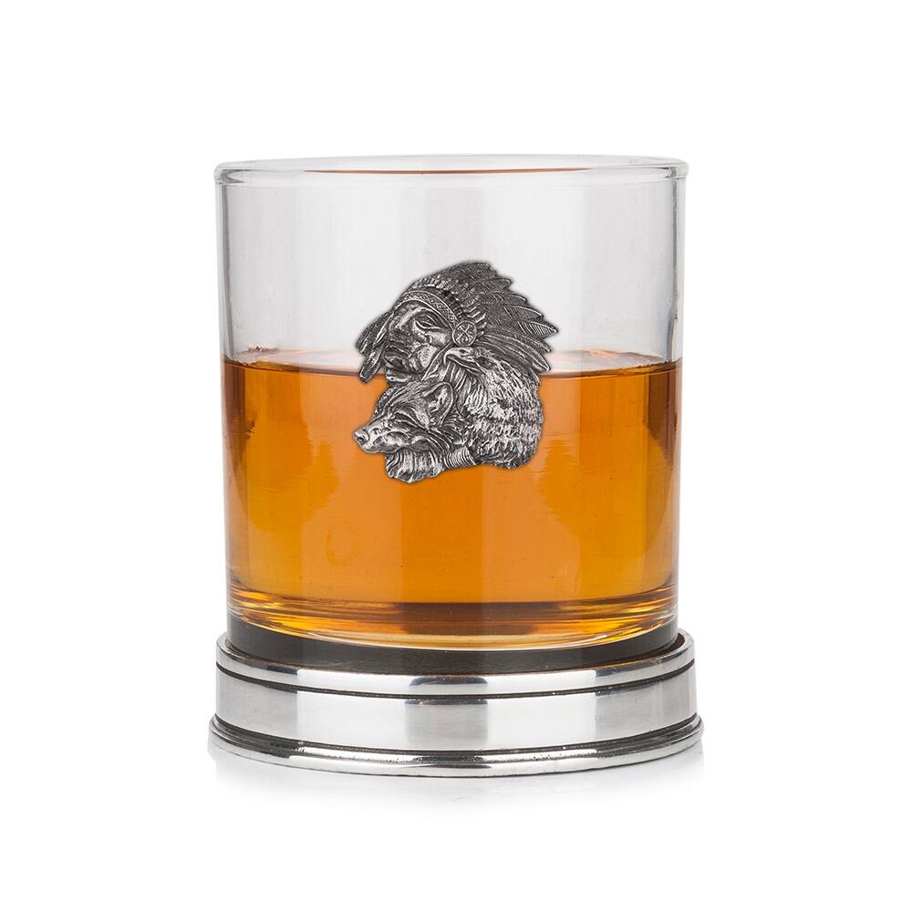 Whisky tumbler with pewter Native American and wolf emblem and polished base, partially filled with amber liquid