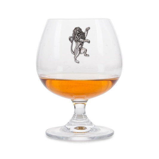 Crystal brandy glass with pewter Rampant Lion emblem, partially filled with amber liquid