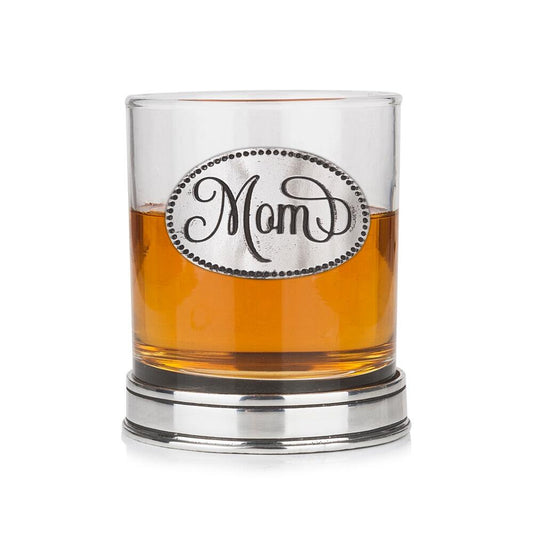 Whisky tumbler with pewter 'Mom' badge and polished base, partially filled with amber liquid