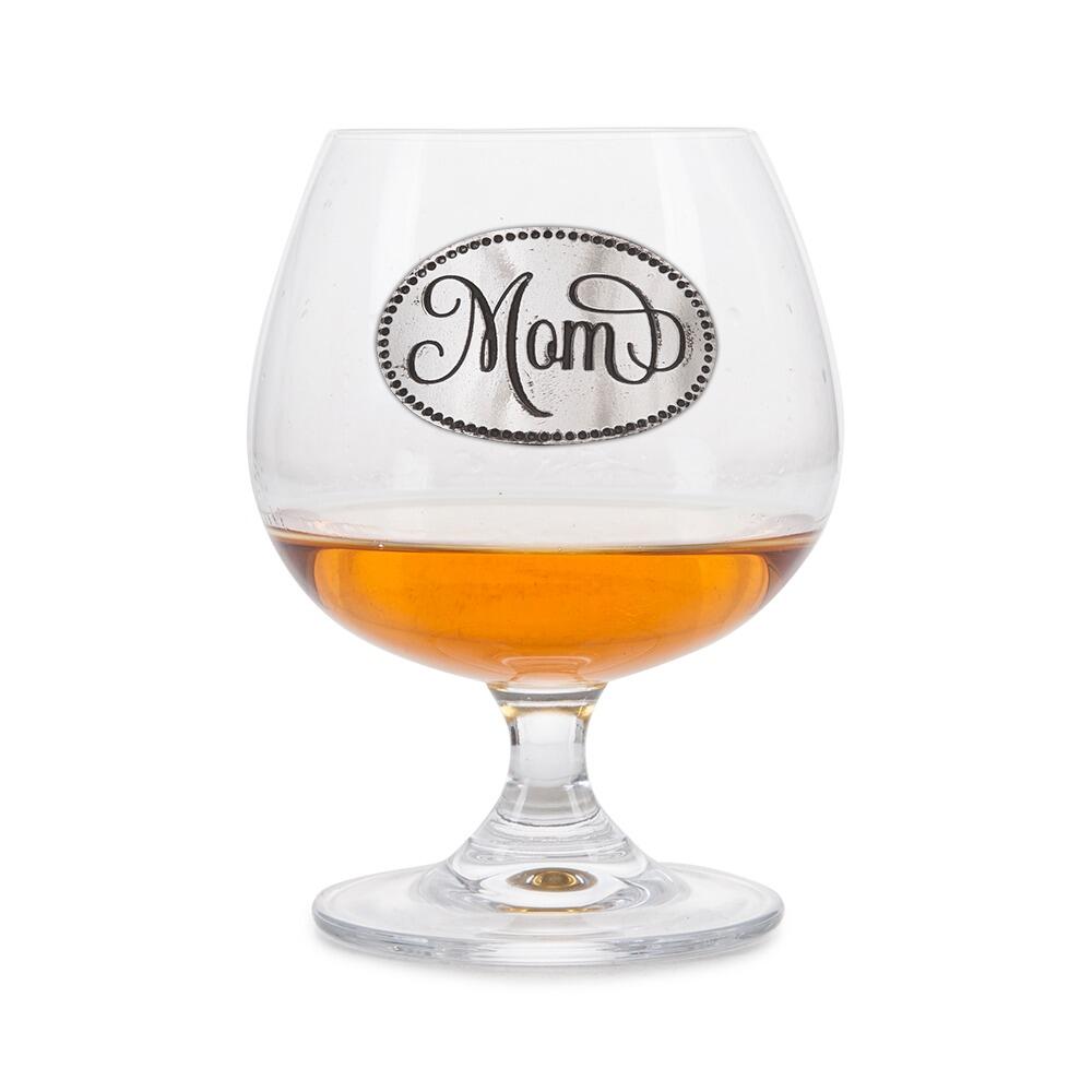 Crystal brandy glass with pewter "Mom" emblem, partially filled with amber liquid