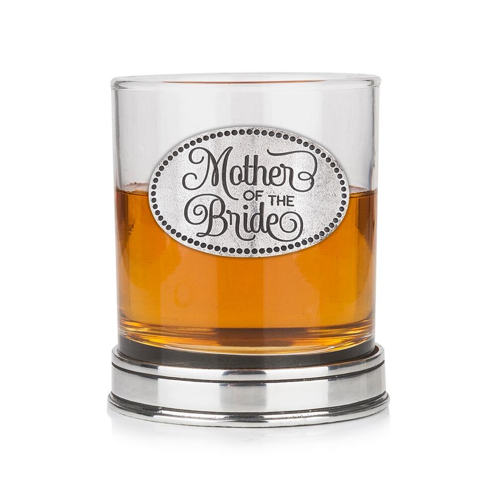 Whisky tumbler with pewter 'Mother of the Bride' badge and polished base, partially filled with amber liquid