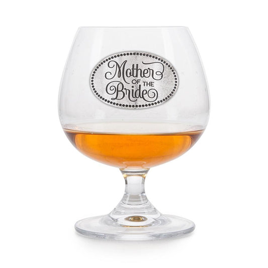 Elegant crystal brandy glass with pewter "Mother of the Bride" badge, partially filled with amber liquid