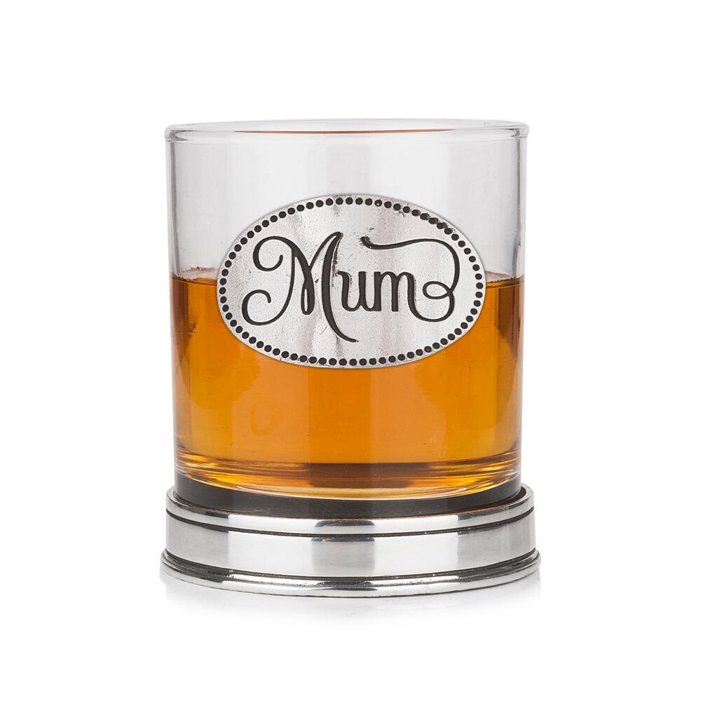 Whisky tumbler with pewter 'Mum' badge and polished base, partially filled with amber liquid
