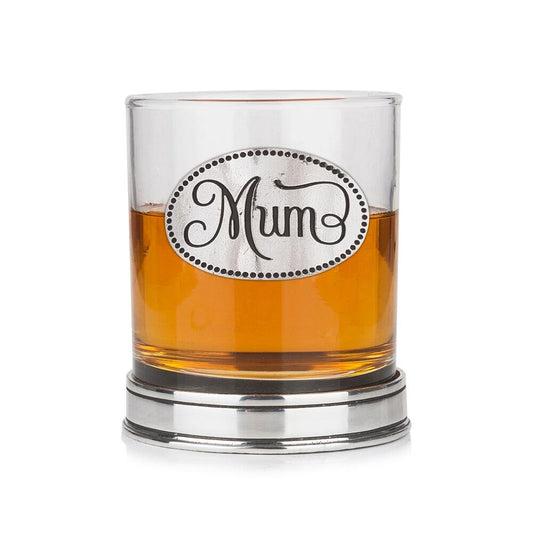 Whisky tumbler with pewter 'Mum' badge and polished base, partially filled with amber liquid