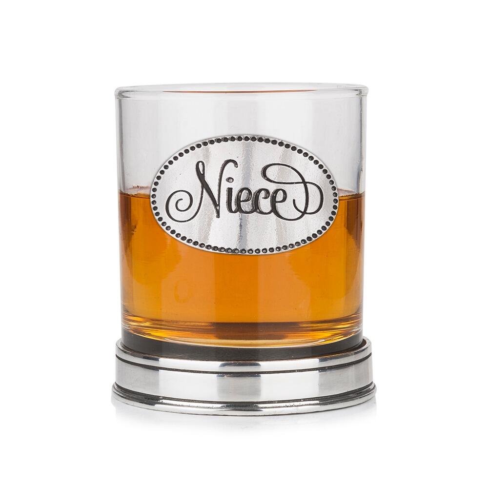 Whisky tumbler with pewter 'Niece' badge and polished base, partially filled with amber liquid
