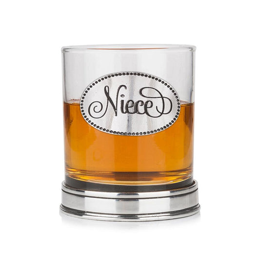 Whisky tumbler with pewter 'Niece' badge and polished base, partially filled with amber liquid