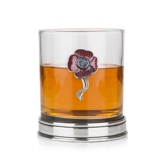 Whisky tumbler with enamelled pewter poppy emblem and polished base, partially filled with amber liquid