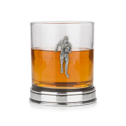 Whisky tumbler with pewter rugby player motif and polished base, partially filled with amber liquid