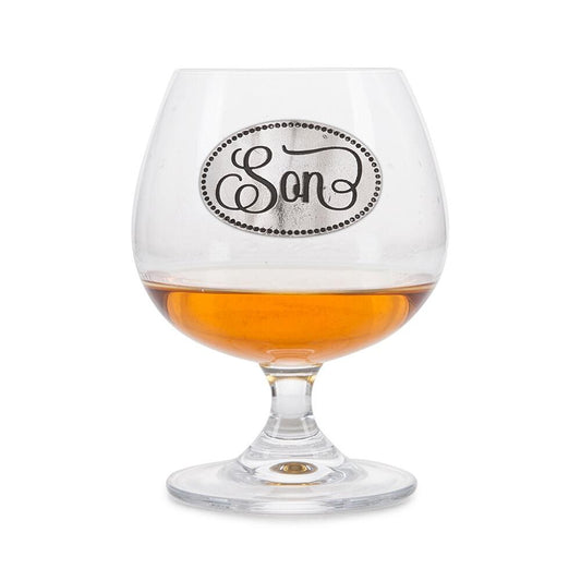 Crystal brandy glass with pewter 'Son' badge, partially filled with amber liquid