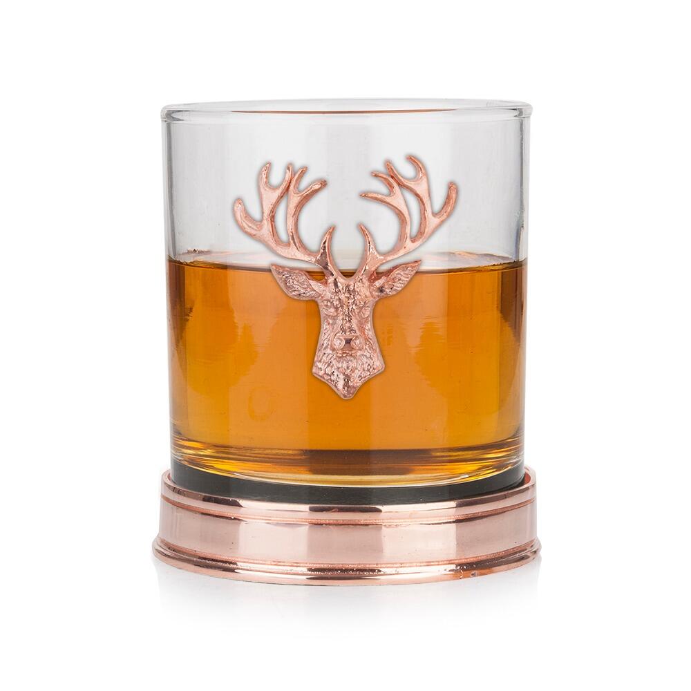 a whisky tumbler with a pewter stag icon and base in copper filled with whisky