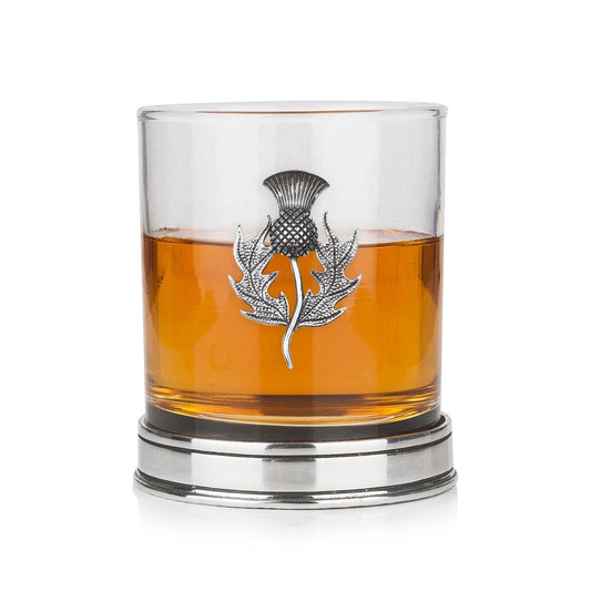 Whisky tumbler with pewter thistle motif and polished base, partially filled with amber liquid