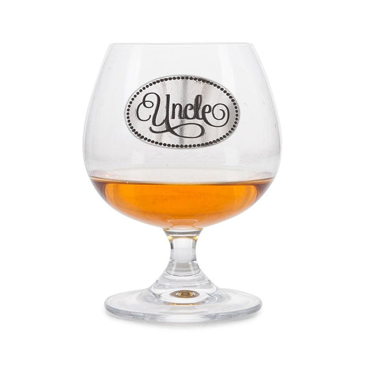 Crystal brandy glass with pewter 'Uncle' badge, partially filled with amber liquid